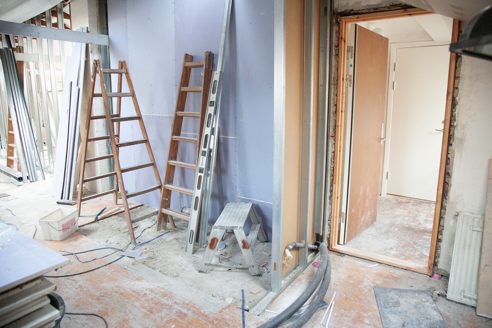 Interior renovation in progress with drywall and construction tools