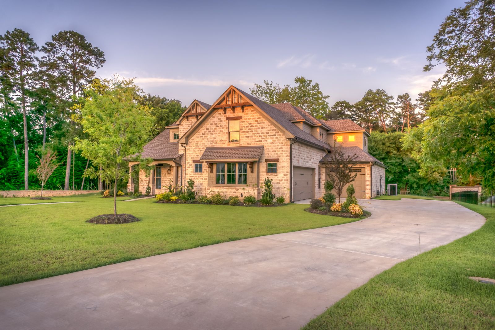 Stone and siding home with a landscaped drive, representing residential additions
